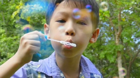 Boy blowing bubbles, slow motion Stock Footage 52852554