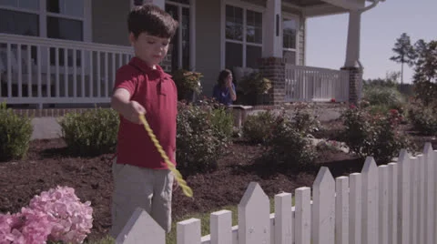 Boy Blowing Bubbles W-Mother in Background Stock Footage 25996156