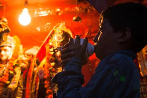 Boy blowing conchshell Stock Photos