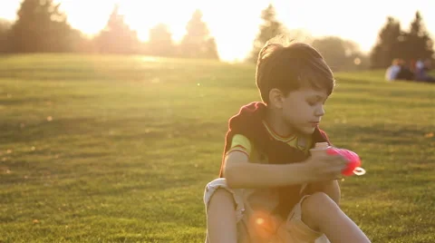Boy blowing the soap bubbles against sunset Stock Footage 56356819
