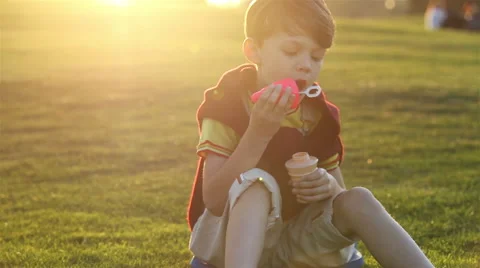 Boy blowing the soap bubbles against sunset Stock Footage 56356868