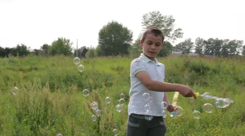 Boy blowing soap bubbles Stock Footage 65205628