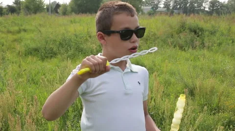 Boy blowing soap bubbles Stock Footage 65488447