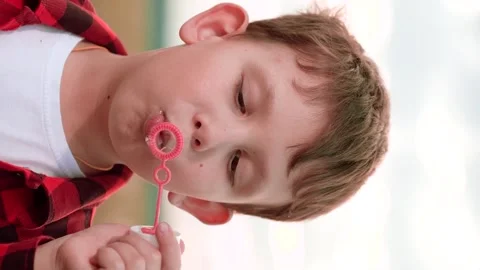 Boy blowing soap bubbles, happy child kid, nature background play, outdoor bubbl Stock Footage 334836678