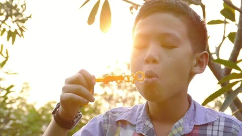 Boy blowing soap bubbles in park ,slow motion. Stock Footage 86889555