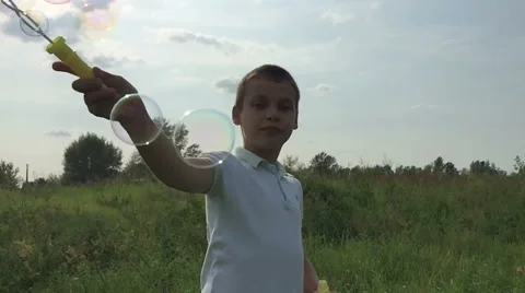 Boy blowing soap bubbles, slow mo Stock Footage 65043752