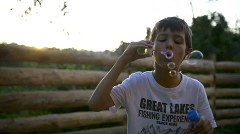 Boy Blowing Soap Bubbles At Sunset, Slow motion Stock Footage