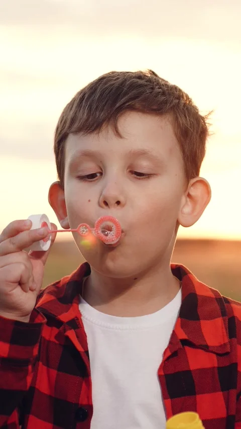 Boy blowing soap bubbles sunset, happy child kid, pure childhood joy, happy Stock Footage 276092434