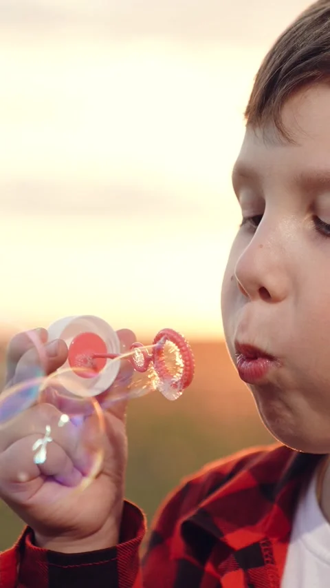 Boy blowing soap bubbles sunset, happy child kid, pure childhood joy, happy Stock Footage 297934190