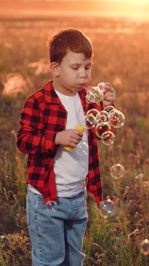 Boy blowing soap bubbles sunset, happy child kid, pure childhood joy, happy Stock Footage 311897006