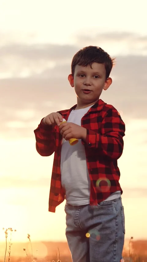 Boy blowing soap bubbles sunset, happy child kid, pure childhood joy, happy Stock Footage 312727429