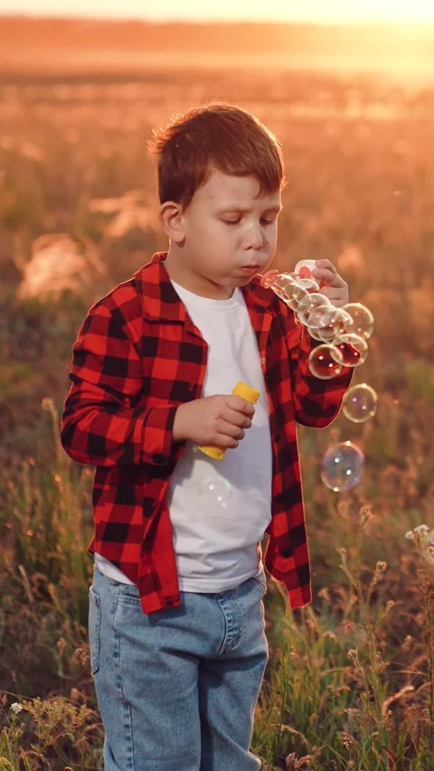 Boy blowing soap bubbles sunset, happy child kid, pure childhood joy, happy Stock Footage 313208445
