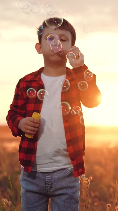 Boy blowing soap bubbles sunset, happy child kid, pure childhood joy, happy Stock Footage 313906354