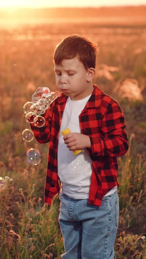 Boy blowing soap bubbles sunset, happy child kid, pure childhood joy, happy Stock Footage 316178126