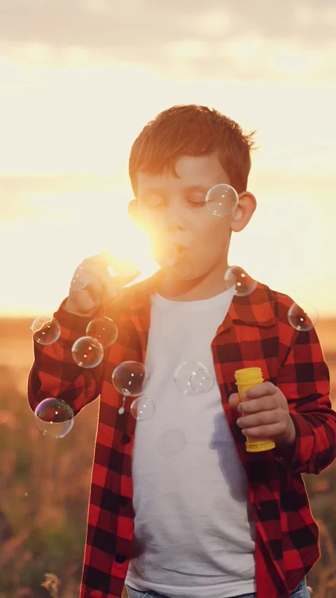 Boy blowing soap bubbles sunset, happy child kid, pure childhood joy, happy Stock Footage 316708850