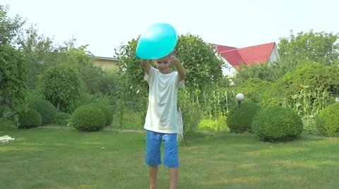 Boy blows the ball by the foot on the grass Stock Footage
