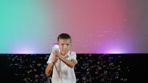 A boy blows bubbles from a gun Stock Footage 341557435