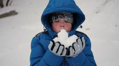 Boy blows snow with hands closeup in slowmo Vidéo 68925217