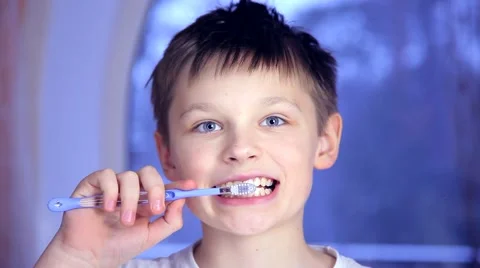 A boy on a blue background brushing his teeth Stock Footage 61173784