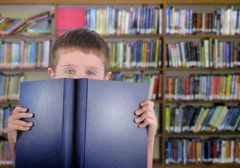 Boy with blue book in library Stock Photos