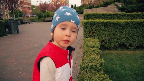 A boy in a blue cap runs in the park. child 2 years Stock Footage 153559925