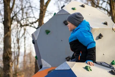 Boy in a blue jacket on a climbing wall, active lifestyle, training course Stock Photos