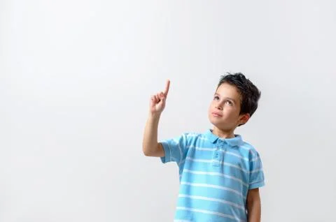 A boy in a blue T-shirt with a brooding face raised his finger up. Stock Photos