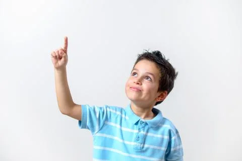 A boy in a blue T-shirt with a brooding face raised his finger up. Stock Photos