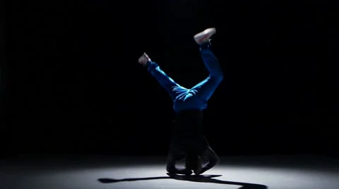 Boy in blue trousers dancing breakdance, on black, shadow Stock Footage 61307057