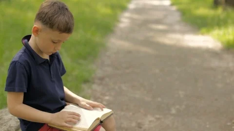 A boy with a book in the park on the mall 스톡 동영상 76135558