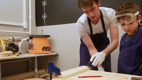The boy is bored in the lesson of carpentry Stockbeeldmateriaal 102239710