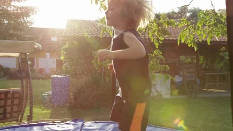 Boy Bounce Trampoline Sunlight - 4k - Slow motion Stock Footage 70448396