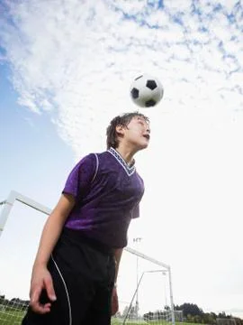 Boy bouncing soccer ball on head Stock Photos