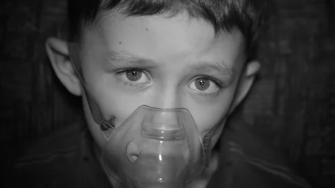 The boy is breathing through the inhaler Stock Footage 80589054