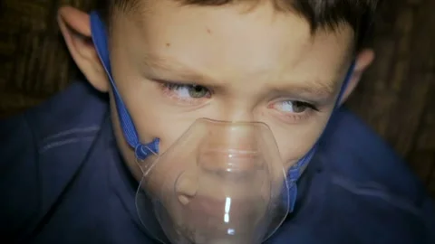 The boy is breathing through the inhaler Stock Footage 127250560