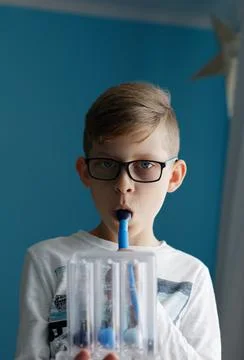 Boy breaths deep exercise with incentive spirometer. Stock Photos