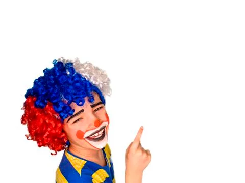 The boy in the bright multi-colored wig. funny mime poses pointing finger at  Stock Photos