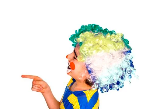 The boy in the bright multi-colored wig. funny mime poses pointing finger at  Stock Photos