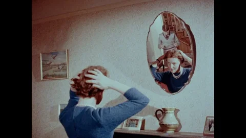 Boy brings mail to a lady making her hair in front of a mirror, UK 1961 Stock Footage 133385518
