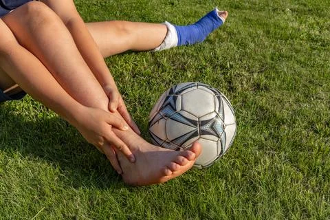 Boy with a broken leg in a cast during a football match an injury to a youn.. Stock Photos