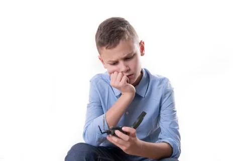 Boy brooding over his future sitting with a compass in his hand and isolated Stock Photos