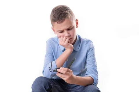 Boy brooding over his future sitting with a compass in his hand and isolated Stock Photos