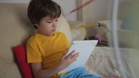 Boy Browsing Social Media on Tablet PC on Hot Heat Summer Day While Sitting on Stock Footage 277967796