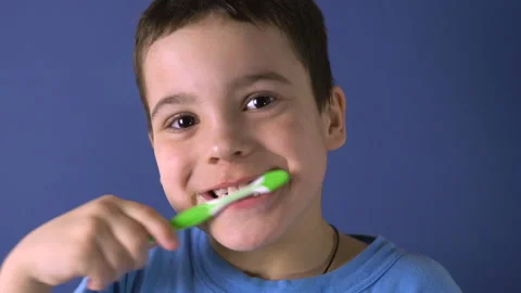 Boy brushes his teeth on a blue background 4K Stock-Footage 126806141