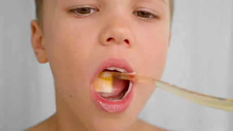 A boy brushes his teeth with a toothbrush and toothpaste in a close-up shot. Stock Footage 278510317