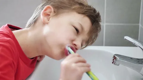 Boy brushing his teeth over the sink Stock Footage 151225190