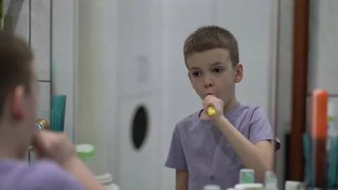 Boy brushing his teeth with a toothbrush in the bathroom. Stock Footage 235933724