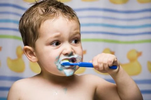 Boy brushing teeth in bathroom Stock Photos