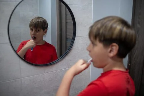 Boy Brushing Teeth Looking At Mirror Reflection Stock Photos
