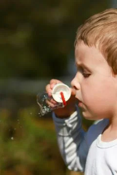 Boy with bubble blower Stock Photos